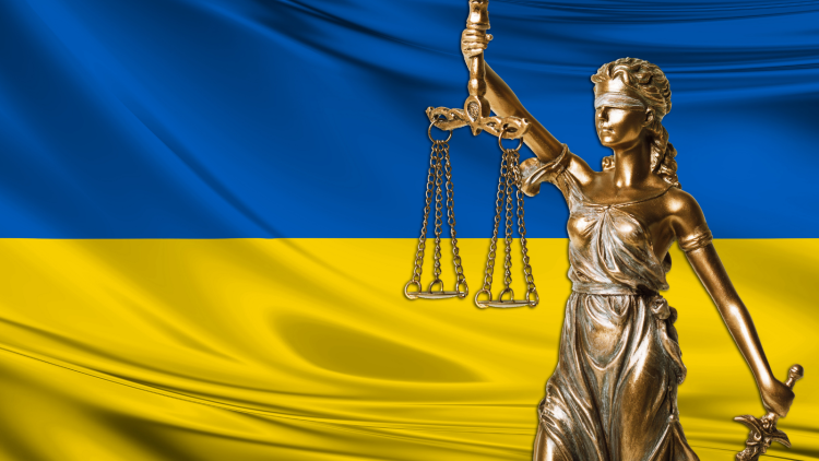 Ukranian canvas flag, in the foreground a bronze sculpture holding a scale.