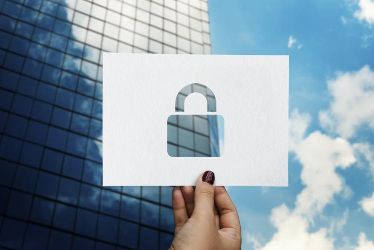 padlock ona  perforated paper in front of modern glass building