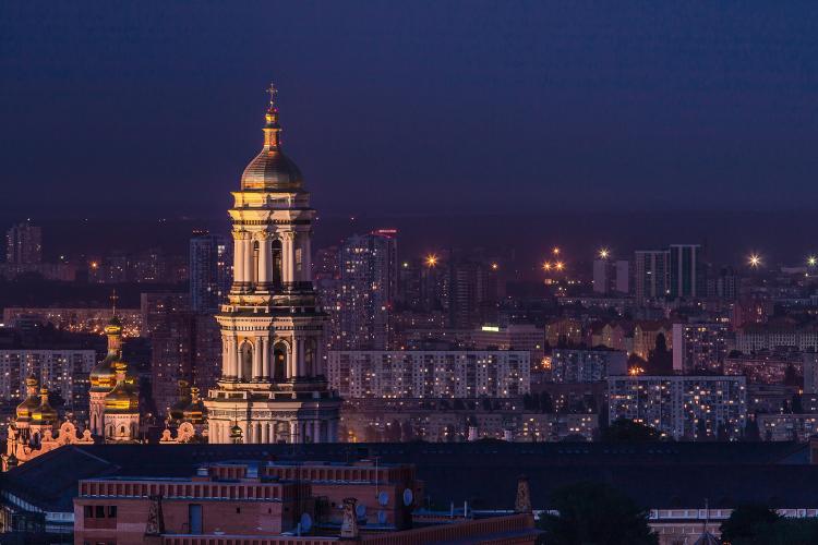 Kyiv at night, picture taken from the sky with some buildings in light, dark sky in the background