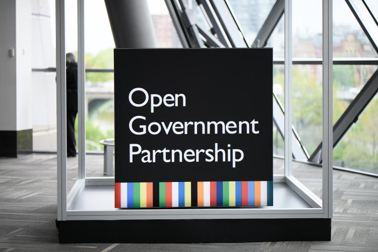 Open government partnership logo in a glass building indoors. 