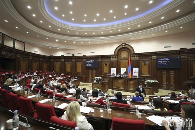 Armenia parliamentary hearings, inside of a room in the parliament, several people sitting while discussing the issues related to new draft law
