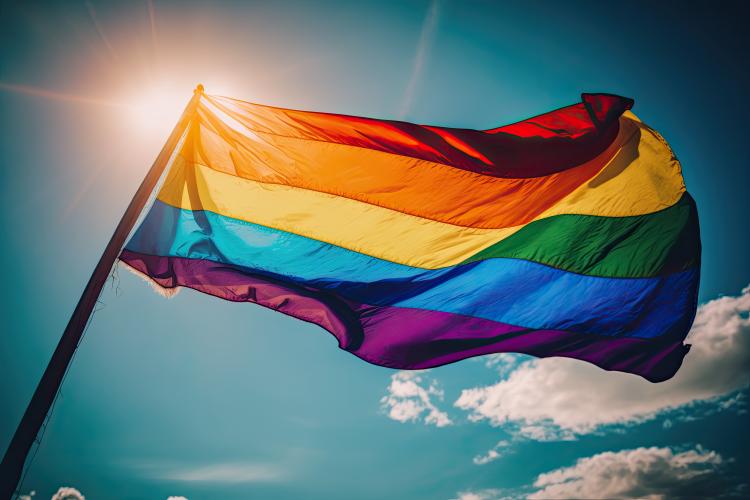 LGBTQ+ pride flag and blue sky