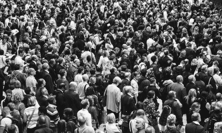 A black and white aerial view of a crowd in public space