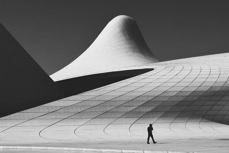 Man walking in front of the Heydar Aliyev Center in Baku.