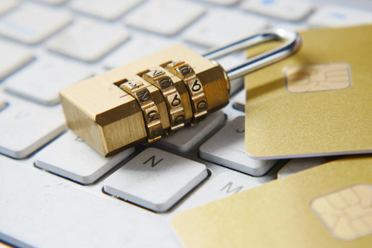 A lock and credit cards placed on a keyboard