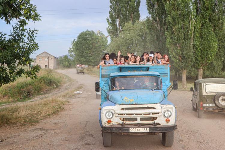 Young people waving from a truck